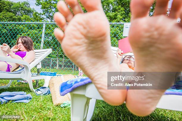 little girl reading book in the chaise lounge - girls soles stock pictures, royalty-free photos & images