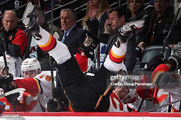 Dougie Hamilton of the Calgary Flames is checked into his bench by Erik Johnson of the Colorado Avalanche in the second period at Pepsi Center on...