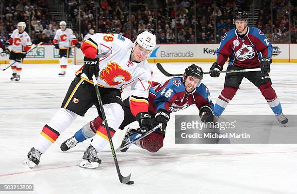 Brandon Gormley of the Colorado Avalanche dives for the puck against Micheal Ferland of the Calgary Flames at the Pepsi Center on January 2, 2016 in...