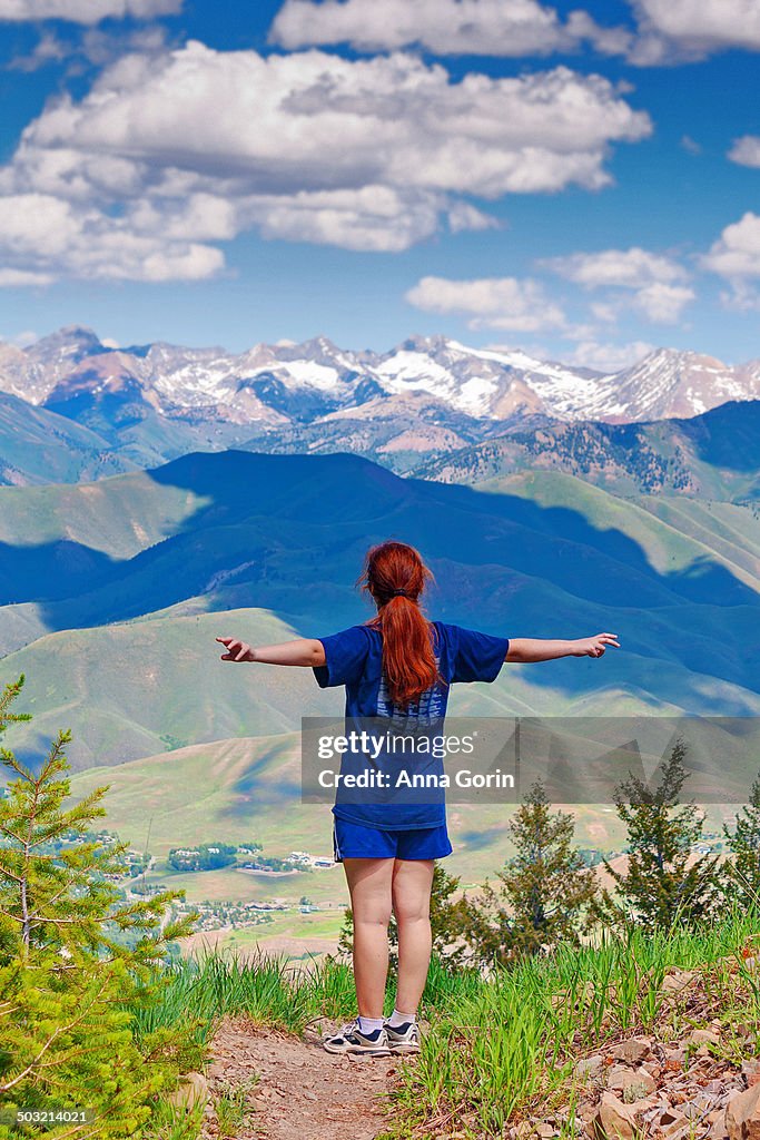 Woman with arms outstretched on hill in Sun Valley