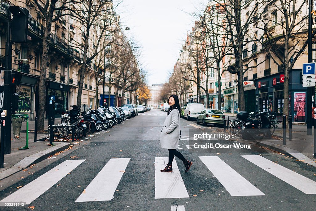 Asian woman crossing zebra in Paris