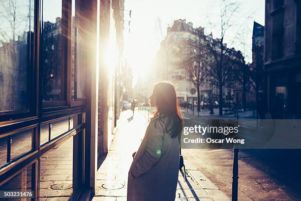 asian woman walking on street in dawn - paris street woman stock pictures, royalty-free photos & images