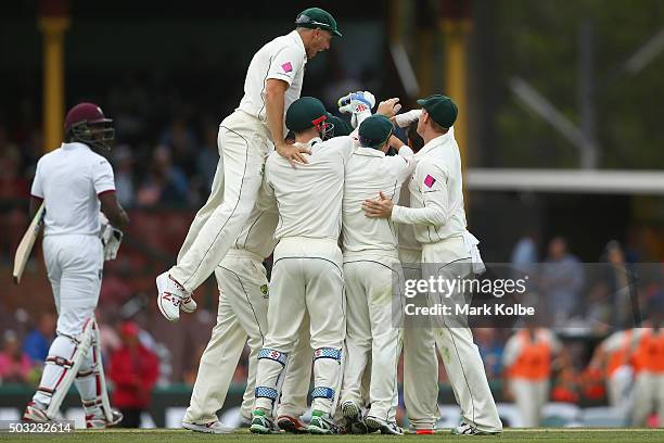 James Pattinson of Australia jumps to join his team mate congratulate Joe Burns of Australia as he celebrates taking the catch to dismiss Jason...