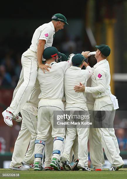 James Pattinson of Australia jumps to join his team mate congratulate Joe Burns of Australia as he celebrates taking the catch to dismiss Jason...