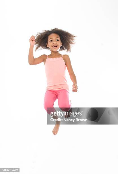 african american young girl jumping for joy. - girls in leggings stock-fotos und bilder