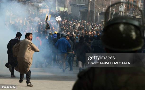 Kashmiri Shiite protesters shout slogans as they run from teargas smoke during a demonstration in Srinagar on January 3 against the execution of...