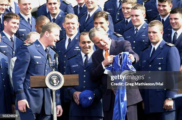 Cadet Mike Thiessen , quarterback for the U.S. Air Force Academy Falcon football team, presenting a team jersey to President George W. Bush on the...