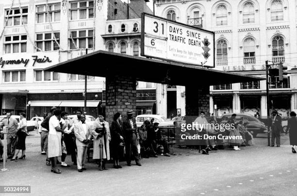 Group of African Americans including American civil rights activist, Rosa Parks waiting at a busy bus stop following a Supreme Court ruling ending...