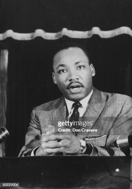 Civil rights leader Rev. Martin Luther King speaking from pulpit at mass meeting abot principles of non-violence before leading assembly to ride...