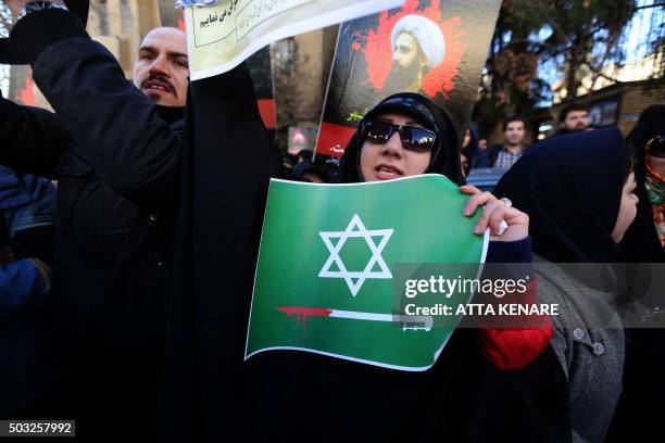 An Iranian woman holding a placard takes part in a demonstration outside the Saudi embassy in Tehran on January 3 against the execution of prominent...