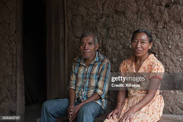 elderly mayan couple sits outside their house - honduras people stock pictures, royalty-free photos & images