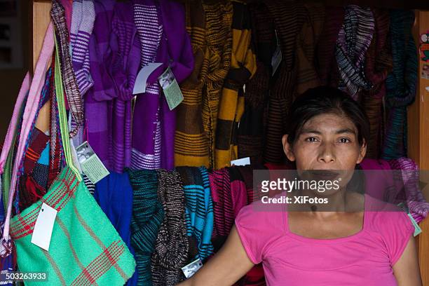 portrait of a mayan woman in front of woven textiles. - honduras stock pictures, royalty-free photos & images