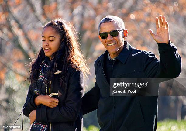 President Barack Obama waves to the assembled press as he walks with his daughter Malia on his family's return to the South Lawn of the White House...