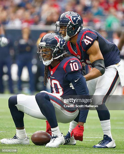 DeAndre Hopkins of the Houston Texans is helped up by Jonathan Grimes after making a catch against the Jacksonville Jaguars in the first quarter on...