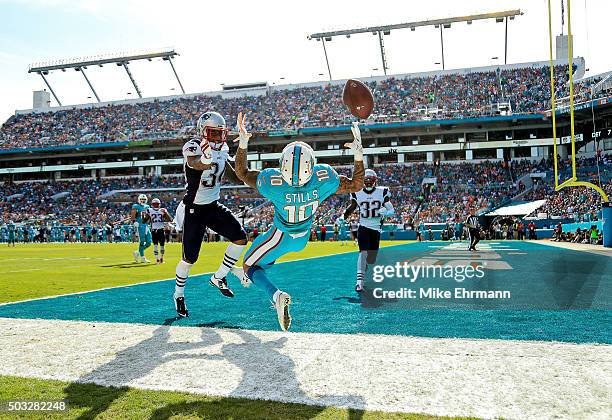 Kenny Stills of the Miami Dolphins attempts to catch a pass while Leonard Johnson of the New England Patriots defends during the first half of the...