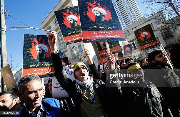 Demonstrators hold posters of Nimr Baqir al-Nimr and shout slogans during a protest rally outside the embassy of Saudi Arabia against the execution...