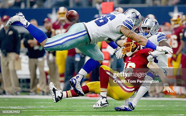 Greg Hardy of the Dallas Cowboys and Terrance Mitchell of the Dallas Cowboys tackle Colt McCoy of the Washington Redskins in the second quarter at...