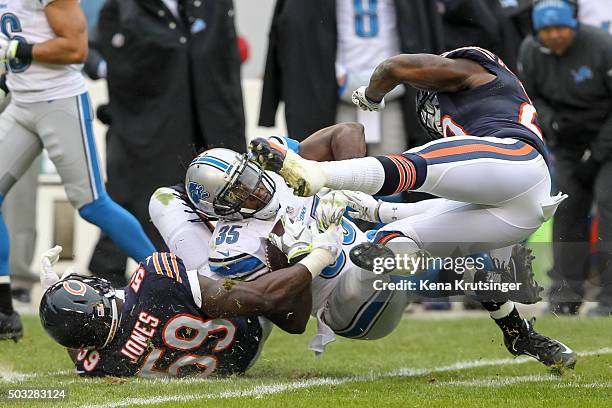 Joique Bell of the Detroit Lions is tackled by Christian Jones and Harold Jones-Quartey of the Chicago Bears at Soldier Field on January 3, 2016 in...