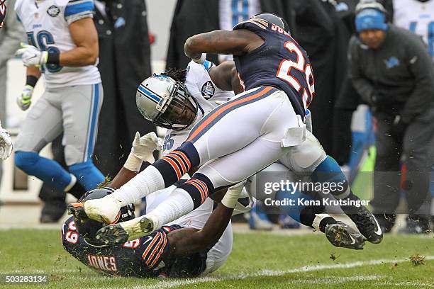 Joique Bell of the Detroit Lions is tackled by Christian Jones and Harold Jones-Quartey of the Chicago Bears at Soldier Field on January 3, 2016 in...