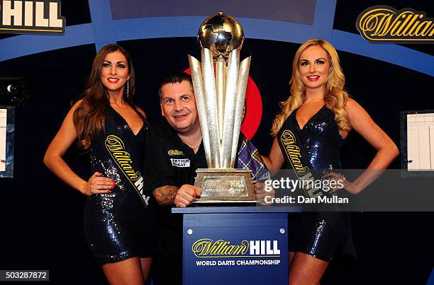 Gary Anderson of Scotland celebrates with the Sid Waddell Trophy alongside the oche girls after defeating Adrian Lewis of England in the final match...