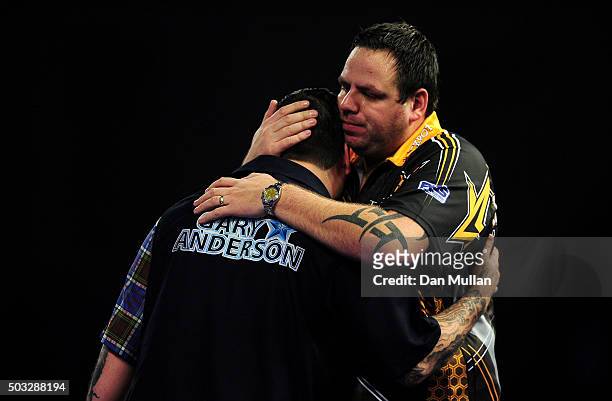 Adrian Lewis of England embraces Gary Anderson of Scotland after being defeated in the final match during Day Fifteen of the 2016 William Hill PDC...