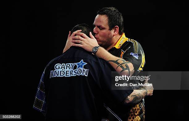 Adrian Lewis of England embraces Gary Anderson of Scotland after being defeated in the final match during Day Fifteen of the 2016 William Hill PDC...