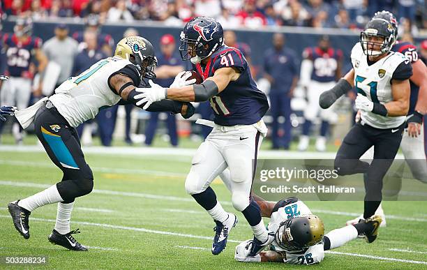 Jonathan Grimes of the Houston Texans runs against Nick Marshall of the Jacksonville Jaguars on January 3, 2016 at NRG Stadium in Houston, Texas.