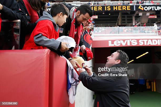 Head coach Jim Tomsula of the San Francisco 49ers signs autographs prior their NFL game St. Louis Rams at Levi's Stadium on January 3, 2016 in Santa...