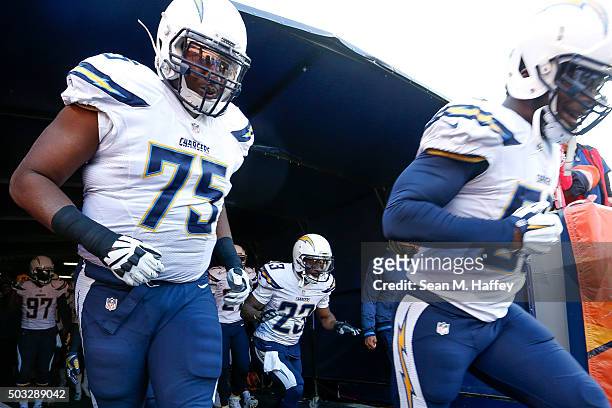 San Diego Chargers players, from left Chris Hairston, Steve Williams, and Tourek Williams emerge from the tunnel before a game against the Denver...