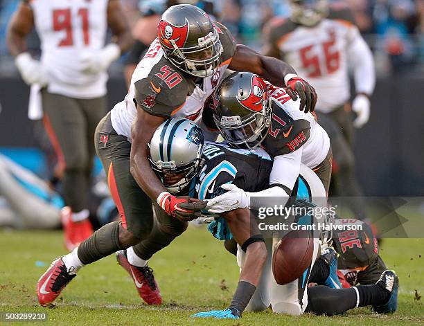 Devin Funchess of the Carolina Panthers fumbles the ball as he is hit by Bruce Carter and Alterraun Verner of the Tampa Bay Buccaneers during their...