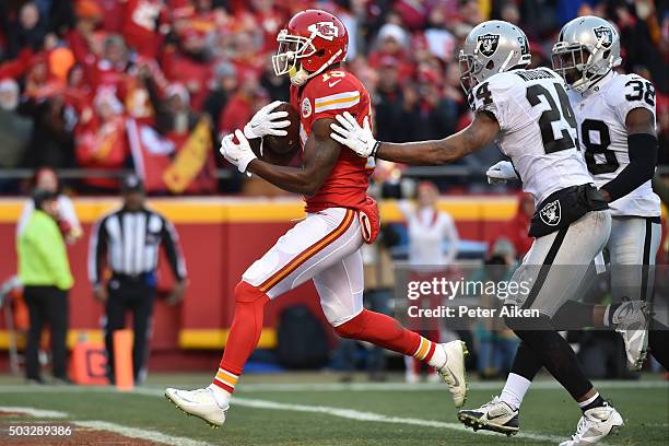 Jeremy Maclin of the Kansas City Chiefs catches the first touchdown of the game between Charles Woodson of the Oakland Raiders and teammate T.J....