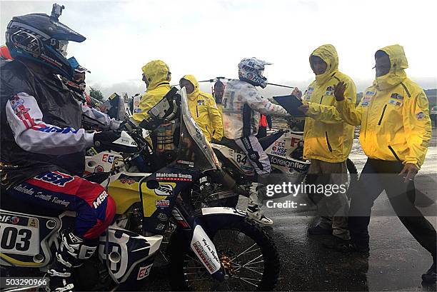 Bikers are stopped by Dakar Rally personnel near the Argentine city of Villa Carlos Paz, after poor weather forced the cancellation of Sunday's...