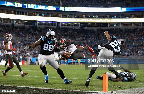 Jameis Winston of the Tampa Bay Buccaneers dives for a touchdown against teammates Kawann Short and Robert McClain of the Carolina Panthers during...