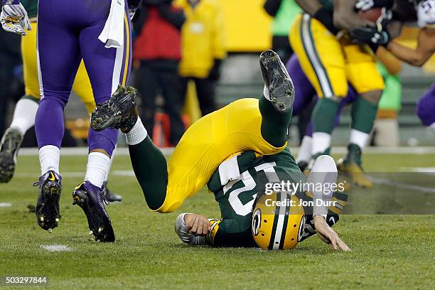 Aaron Rodgers of the Green Bay Packers falls after throwing a pass during the second quarter against the Minnesota Vikings at Lambeau Field on...