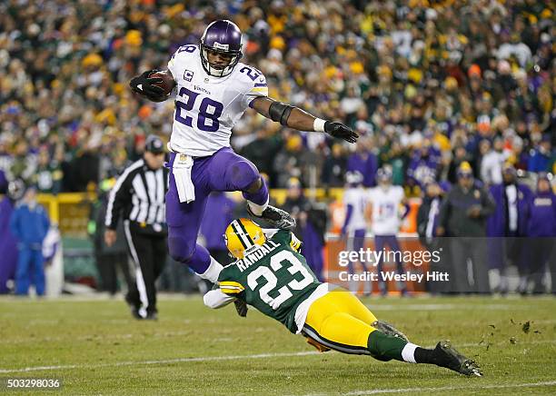 Adrian Peterson of the Minnesota Vikings hurdles Damarious Randall of the Green Bay Packers during the third quarter of their game at Lambeau Field...