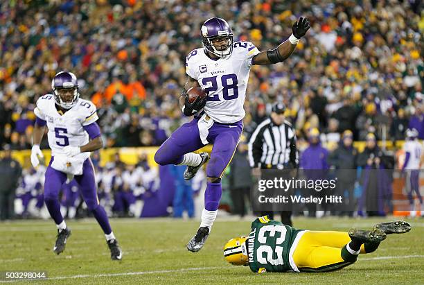 Adrian Peterson of the Minnesota Vikings hurdles Damarious Randall of the Green Bay Packers during the third quarter of their game at Lambeau Field...