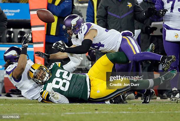Richard Rodgers of the Green Bay Packers loses the ball as he is tackled by Eric Kendricks and Andrew Sendejo of the Minnesota Vikings during the...