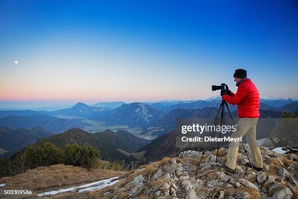 photographer at top of a mountain in the alps - spiegelreflexcamera stockfoto's en -beelden