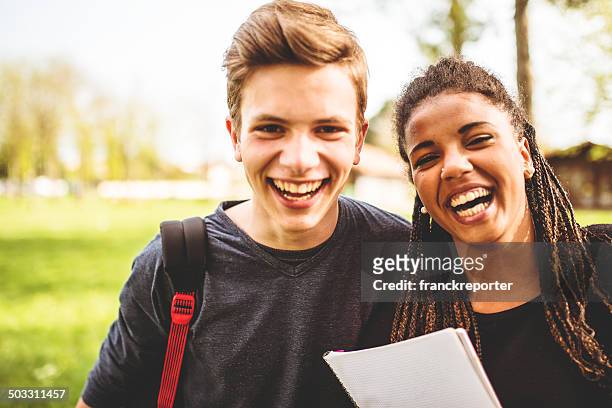 paar teenager-student im freien lachen - boy hug males stock-fotos und bilder
