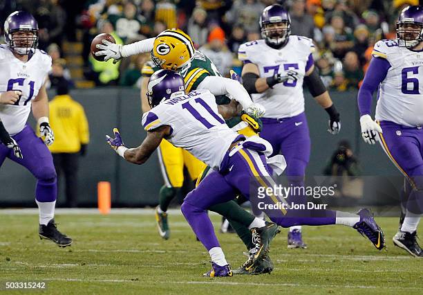 Micah Hyde of the Green Bay Packers intercepts a pass intended for Mike Wallace of the Minnesota Vikings during the third quarter of their game at...