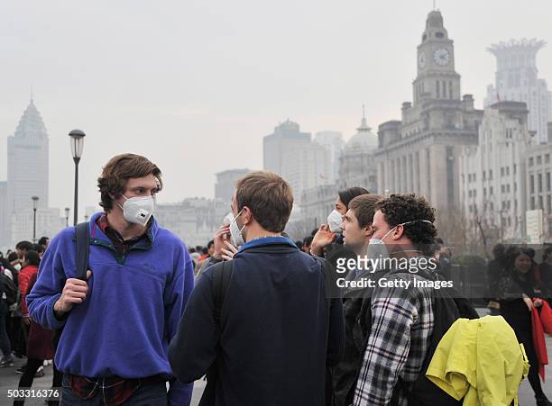 Tourists wearing breathing masks visit The Bund in the smog on January 3, 2015 in Shanghai, China. The air quality index in Shanghai reached 230 in...