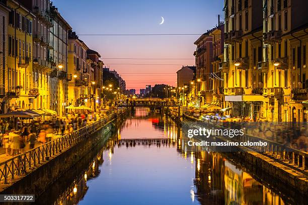people walk on the sides of the naviglio grande canal in milan - milano notte foto e immagini stock