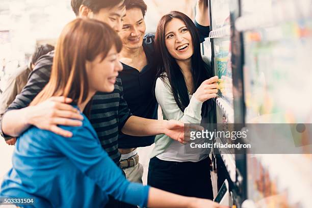 japonês amigos em uma máquina de venda automática - máquina de venda automática imagens e fotografias de stock