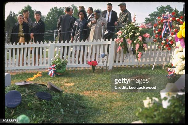 Visitors at grave site pay respects to slain President John F. Kennedy on first birthday after the assassination.