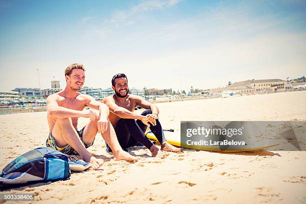 mixed race friends with surfboard at bondi beach, australia - bondi beach stockfoto's en -beelden