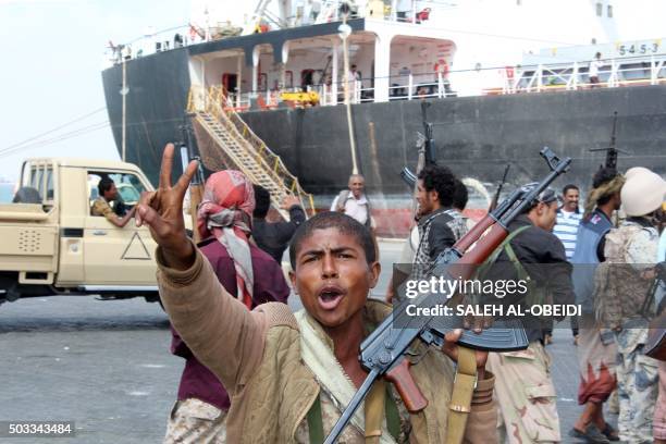 Fighters loyal to Yemen's President Abedrabbo Mansour Hadi celebrate after they managed to secure completely and take control of the port of the...