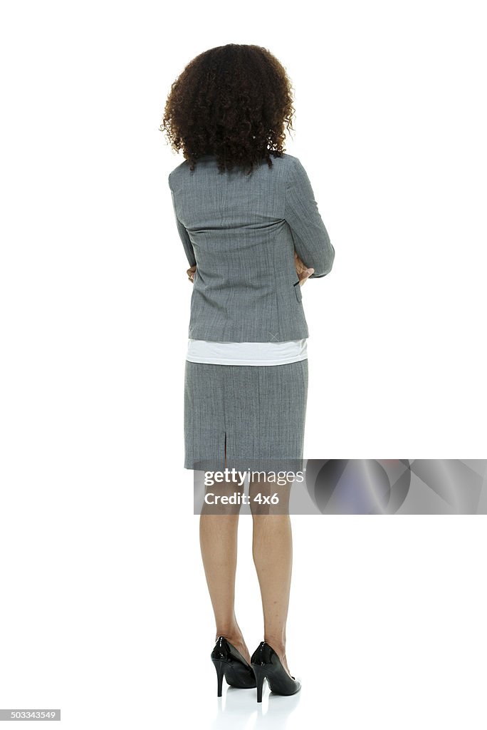 Vista posteriore della donna d'affari in piedi & guardando lontano