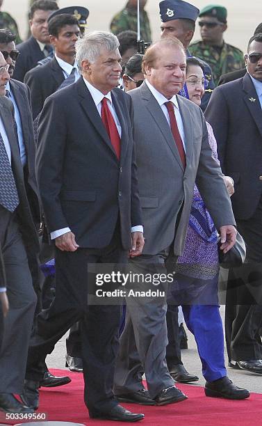 Pakistani Prime Minister Nawaz Sharif and his wife Kalsoom Nawaz Sharif walk near Sri Lankan Prime Minister Ranil Wickremesinghe at Bandaranaike...