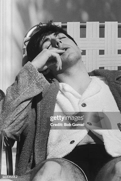 Paul McCartney, member of British rock group, The Beatles, relaxing on lounge chair at poolside of the Deauville Hotel.