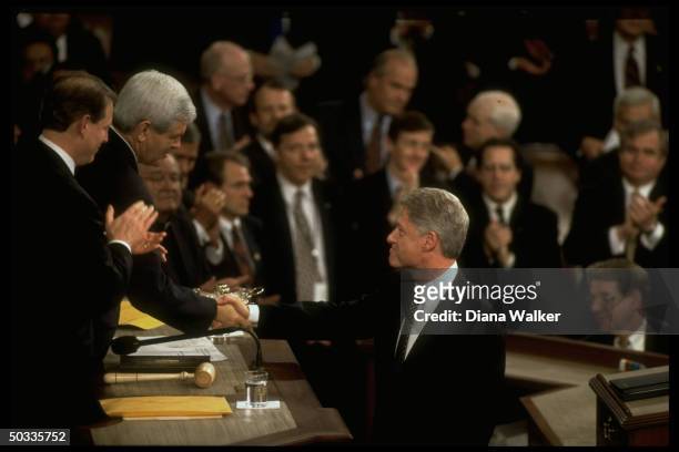 Pres. Bill Clinton shaking hands w. House Speaker Newt Gingrich as VP Al Gore applauds, during his State of Union address to Joint Session of...